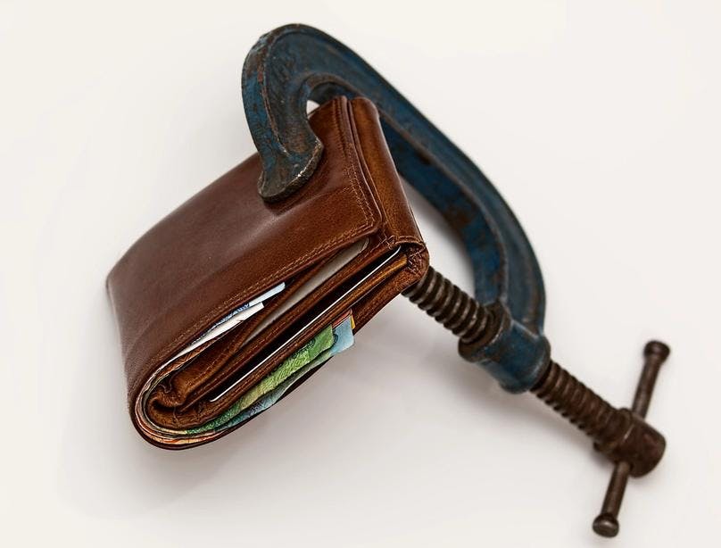 A wrench holding a moneybag to represent budget measurement