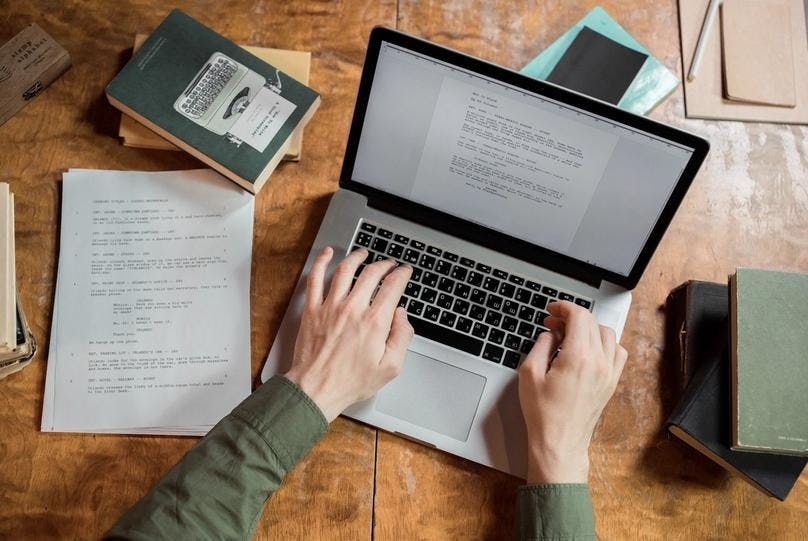 Both hand typing English language on a laptop