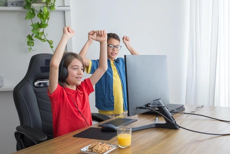 Two kids celebrating for winning a typing game