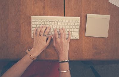A female hand is typing on a keyboard