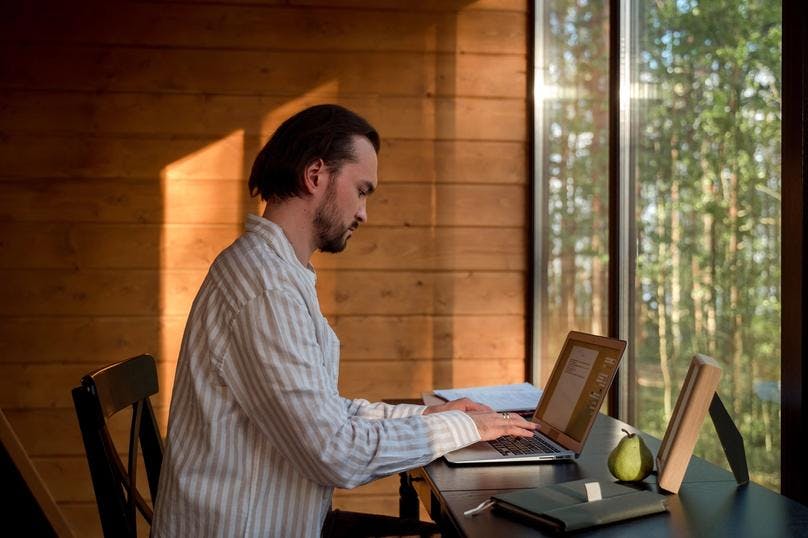 a man maintaining proper typing posture while typing on his laptop