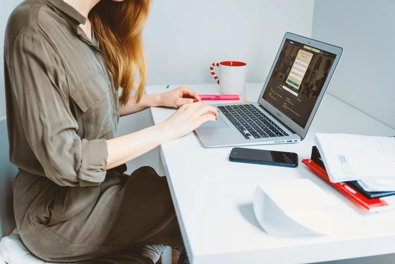 A lady having proper ergonomics, typing on a laptop